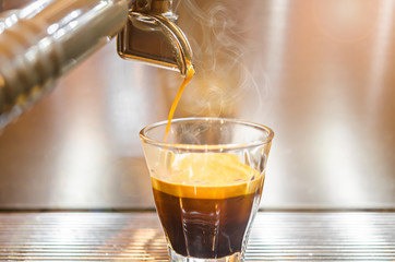 Barista making a espresso with a classic coffee machine.
