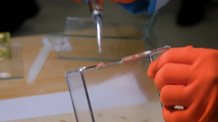 Design, handmade and art concept - professional woman decorator, designer working with soldering iron and making glass gift keepsake box at workshop, studio