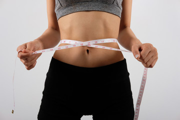 sporty fitness woman in sportswear with measuring waist with tape. healthy sport lifestyle