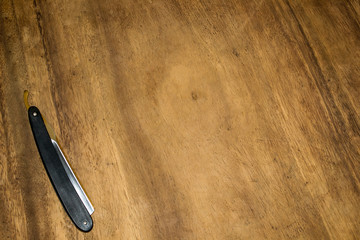Clasic straight razor on wodden background