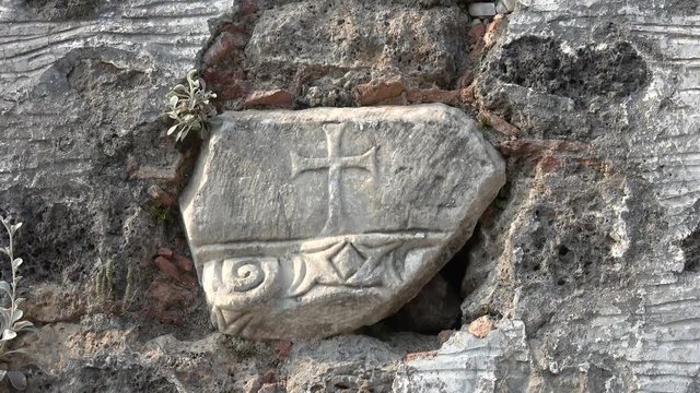 Kayakoy, Fethiye, Turkey - 12th of June 2019: 4K Antique stone with Cross on in embedded in wall