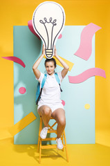 Portrait of schoolgirl with big light bulb