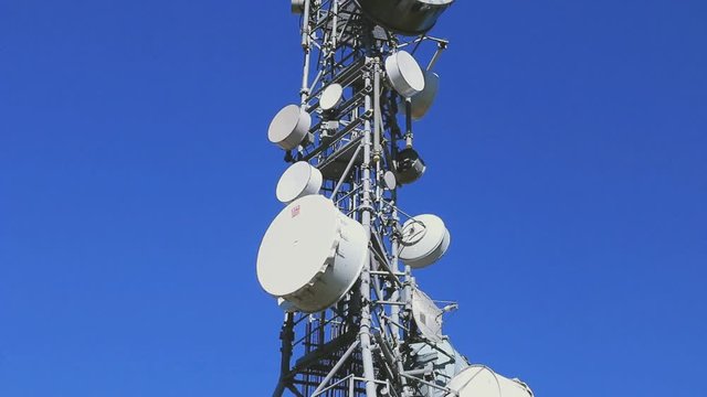 Radars et antennes sur fond de ciel bleu.