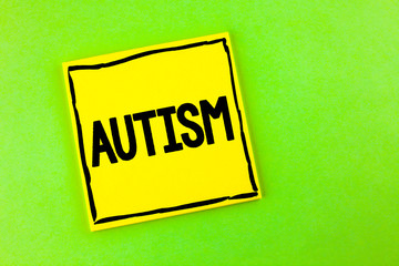 Handwriting text Autism. Concept meaning Autism Awareness conducted by social committee around the globe written Yellow Sticky Note Paper the plain background.