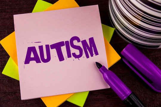 Text sign showing Autism. Conceptual photo Autism Awareness conducted by social committee around the globe written Sticky note paper wooden background Marker and Cup next to it.