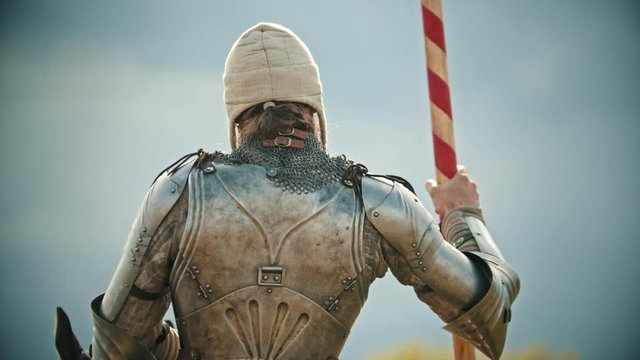A man knight in the armor holding a spear