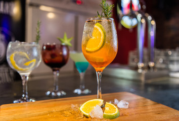 colorful gin tonic cocktails in wine glasses on bar counter in pup or restaurant
