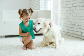 A child with a dog. Girl with a Labrador at home. 