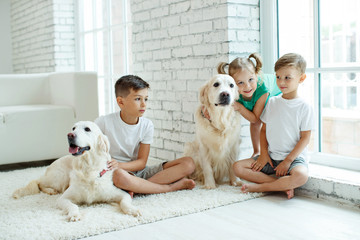 Children with a dog. Happy family with a dog to themselves at home.
