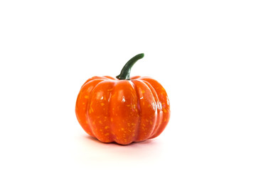 One decorative artificial little pumpkin on a white background. Orange vegetable dummy for home decoration for Autumn Holiday, Halloween