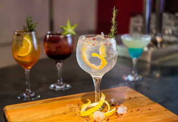 colorful gin tonic cocktails in wine glasses on bar counter in pup or restaurant