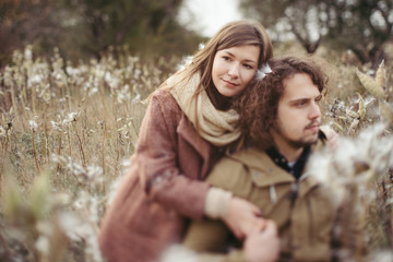 Young happy caucasian couple expecting a baby. Pregnant woman and her husband walking and having fun together outdoors in the autumn. Family, parenthood, love, happiness concept.