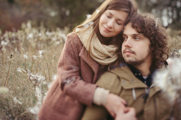 Young happy caucasian couple expecting a baby. Pregnant woman and her husband walking and having fun together outdoors in the autumn. Family, parenthood, love, happiness concept.