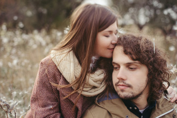 Fototapeta premium Young happy caucasian couple expecting a baby. Pregnant woman and her husband walking and having fun together outdoors in the autumn. Family, parenthood, love, happiness concept.
