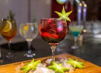 colorful gin tonic cocktails in wine glasses on bar counter in pup or restaurant