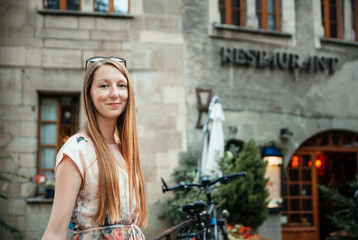 Naklejka premium Young woman with long hair and freckles in the city in summer