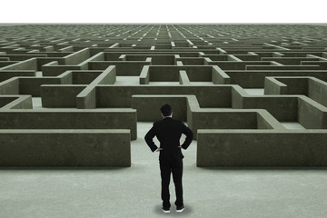 Businessman going straight ahead on a wide road between mazes