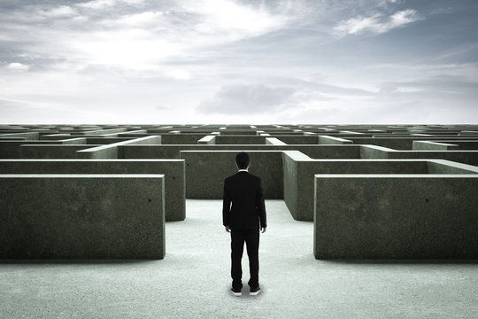 Businessman going straight ahead on a wide road between mazes
