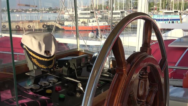 Ece Marina, Fethiye, Turkey - 11th of July 2019: 4K Captain's cap on the wheelhouse console of a vessel on the berth