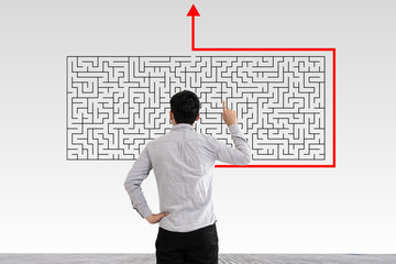 Businessman in doubt looking to a maze and searching the way out