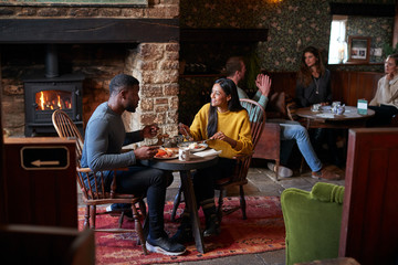 Couple At Table In Traditional English Pub Eating Breakfast