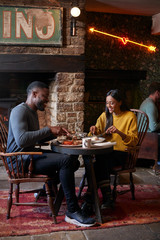 Couple At Table In Traditional English Pub Eating Breakfast