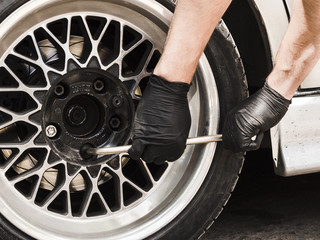 Man using a wrench to tighten wheel nuts