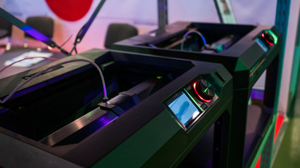 Print head of 3D printer machine during work at modern scifi technology exhibition. 3D printing, additive technologies, 4.0 industrial revolution and futuristic concept