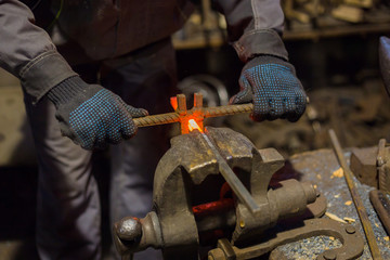 Professional blacksmith working with metal at forge, workshop. Handmade, craftsmanship and...