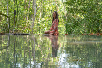 Fototapeta na wymiar Young woman near turquoise water of cascade waterfall at tropical rain forest, island Koh Phangan, Thailand