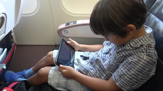 Turkish Airlines, Turkey - 18th of June 2019: 4K Child with tablet waits in the plane for departure