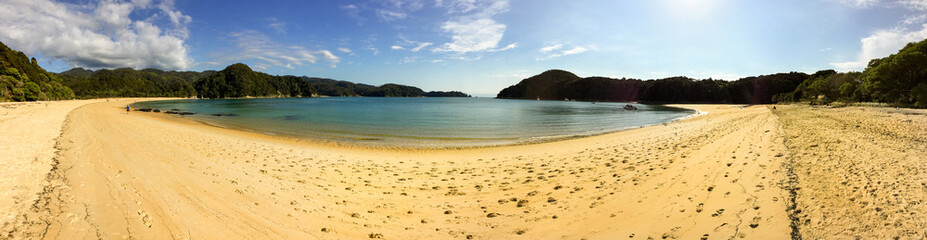 A sweeping panoramic view of  a beautiful golden beach and cove in Able Tasman National Park, New Zealand