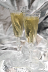 Two champagne glasses on blurred silver background