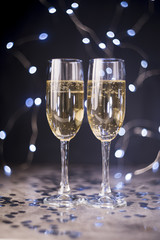 Champagne glasses on table with silver confetti at nightclub