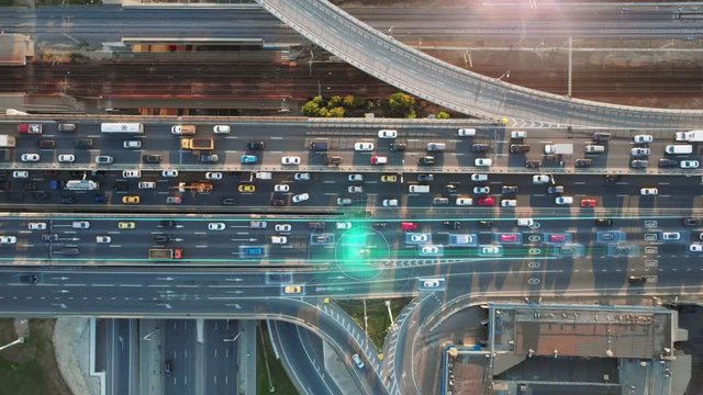 Beautiful aerial presentation of the autonomous cars self-driving concept on multi-level highway in Moscow. Direct top view to the road traffic in a big city on the sunny evening.