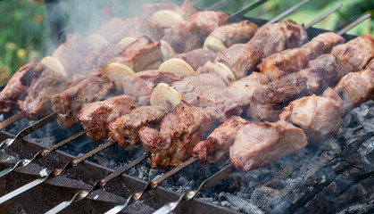 The meat is fried barbecue on a skewer in the garden with smoke