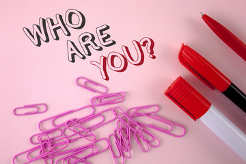 Writing note showing Who Are You Question. Business photo showcasing Introduce or Identify Yourself Tell your Personal Story written plain Pink background Pen Marker and Paper Pins next to it.