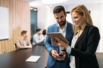 Businesspeople discussing while using digital tablet in office