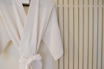 White bathrobe on a hanger on the wall