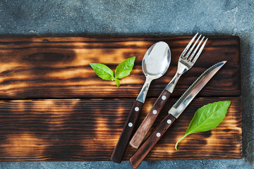 Rustic set of cutlery knife, spoon, fork on black background