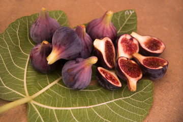 fresh figs whole and cut on a fig leaf