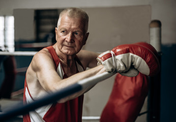 Elderly boxer thinks about tactics before a fight in the ring