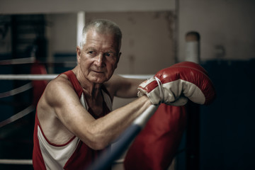 Elderly boxer thinks about tactics before a fight in the ring