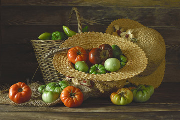 Colorful tomatoes in a straw wicker hat.