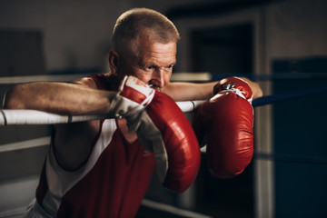 An elderly boxer in the ring thinks about his defeat.