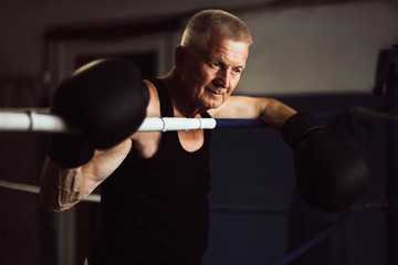 Elderly boxer thinks about tactics before a fight in the ring
