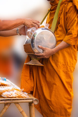 Thai people make merit by giving food to monks.