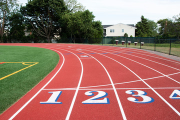 Common start-finish line of a red track with white numbers with blue trim