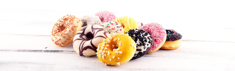 assorted donuts with chocolate frosted, pink glazed and sprinkles donuts
