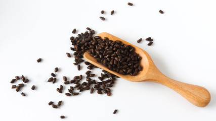 Top view of fetid cassia seed also called ketsumei-shi on wooden spoons isolated on a white background. Asia traditional Chinese medicine. Good for the eyes. .Cassia herb Tea. With copy space.